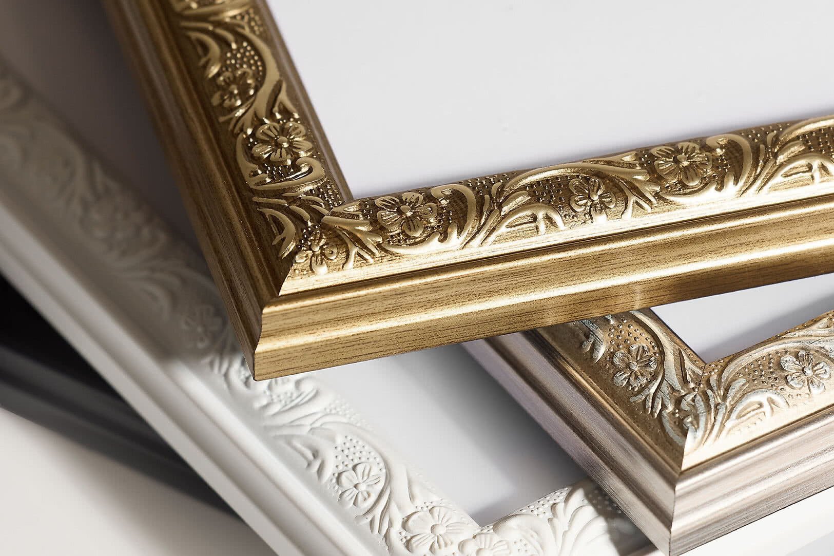 Close-up van sierlijke hoeken van gouden en witte klassieke lijsten
