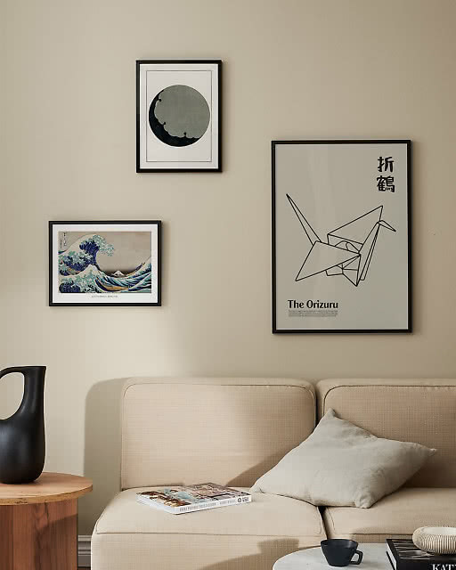 Three Japanese-themed prints — a Hokusai wave, dark moon, and origami crane Orizuru print — above a cream sofa.