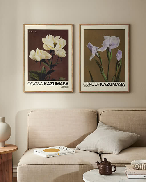 Two Ogawa Kazumasa botanical prints — white peonies and purple iris — displayed above a neutral linen sofa.