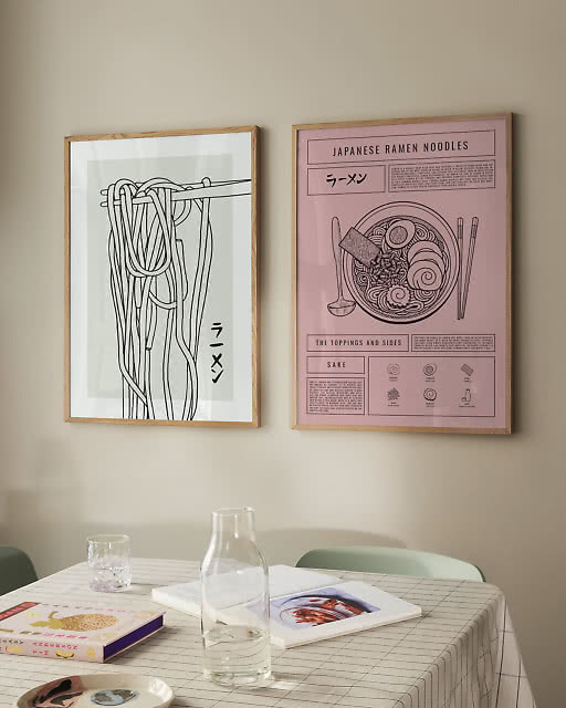 A minimal ramen line drawing and a pink Japanese Ramen Noodles infographic print above a grid-cloth dining table.