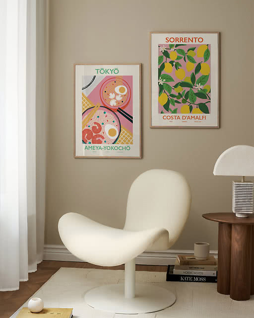 A Tokyo ramen print and a Sorrento lemon print displayed above a sculptural white lounge chair.