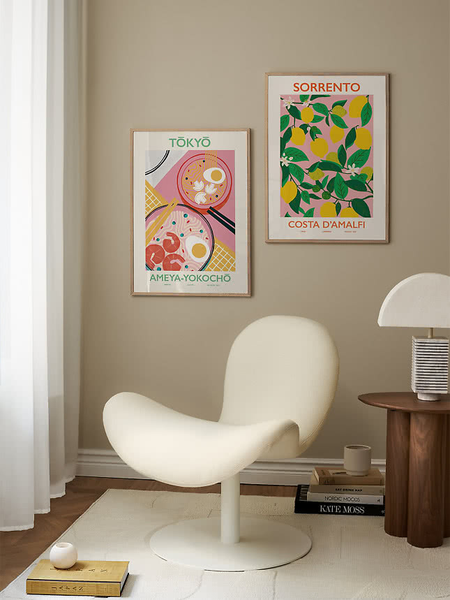 Affiches de voyage Tokyo et Sorrento au-dessus d'un fauteuil lounge blanc