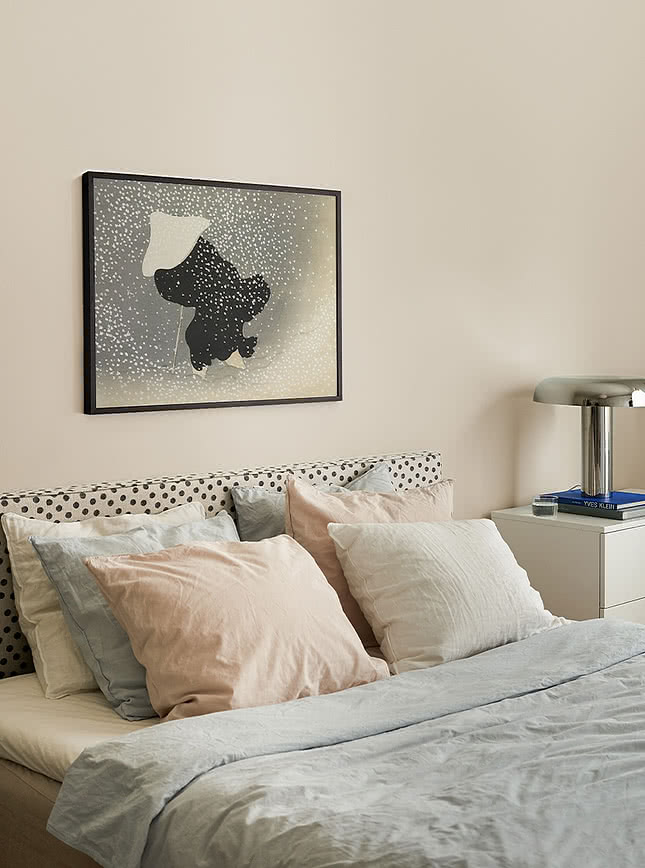 Speckled abstract art print hanging above a bed