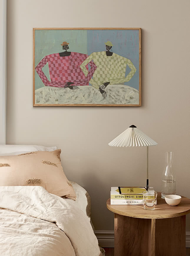 Art print of two figures hanging above a bed