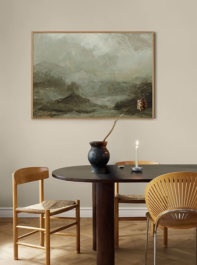 Misty landscape print hanging above a dining table