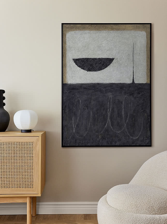 Grey abstract art print above a rattan sideboard