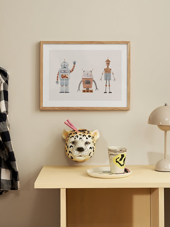 Affiche de robot au-dessus d'une table d'appoint jaune avec un vase léopard