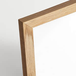 Primer plano de una esquina de marco de madera clara sobre fondo blanco