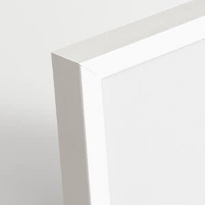 Close-up of the corner of a white picture frame against a light gray background