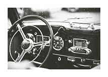 Primo piano in bianco e nero di volante e cruscotto di un'auto d'epoca