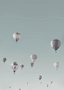 Meerdere luchtballonnen zweven in een lichtblauwe lucht