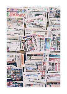 Présentoir rempli de journaux et magazines internationaux en plusieurs rangées
