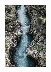 Fiume turchese che scorre in una stretta gola rocciosa tra pietre e vegetazione