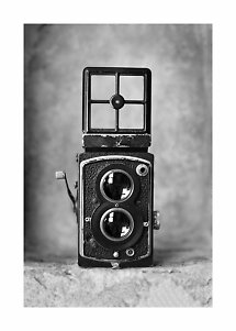 Foto vintage in bianco e nero di una vecchia fotocamera biottica con mirino aperto.