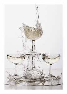 Tre coppe da champagne con vino frizzante chiaro e schizzi d'acqua su sfondo bianco
