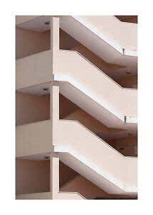 Vano scale geometrico di edificio beige con passerelle diagonali ripetute