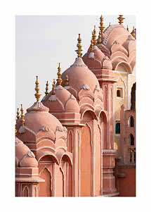 Façade rose avec dômes, arches et flèches dorées sur fond de ciel clair