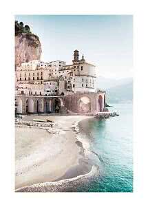 Coastal town with church, cliff, arched walkway and sandy beach by turquoise sea