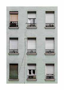 Apartment facade with nine windows, shutters, and small black balcony railings