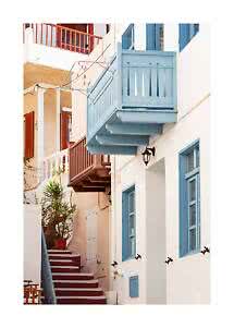 Narrow alley with white houses, blue balconies and windows, red steps, and potted plants