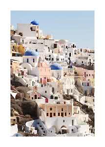 White houses with blue domes on a sunny Santorini hillside under a clear blue sky