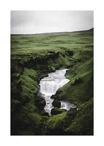 Pequeña cascada en un cañón verde y musgoso bajo un cielo nublado