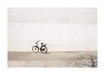Bicicletta da città nera con cestino parcheggiata davanti a un grande muro di cemento chiaro