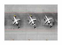 Luftfoto af tre hvide fly parkeret ved gaten på en grå lufthavnsforplads