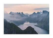 Paisaje de fiordo brumoso con montañas escarpadas y agua tranquila al suave amanecer