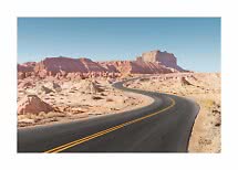 Carretera asfaltada sinuosa por el desierto con rocas rojas bajo un cielo azul despejado