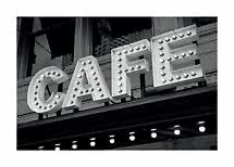 Foto in bianco e nero di un'insegna café illuminata con lampadine su edificio