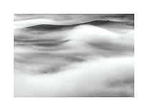 Paesaggio in bianco e nero con cime montuose avvolte da nuvole e nebbia