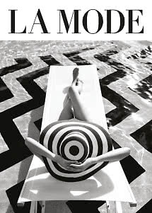 Black-and-white fashion image of person on lounger by pool with large striped hat