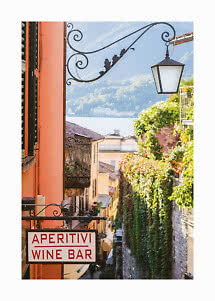 "Aperitivi Wine Bar" sign on a sunny narrow street with hanging lantern and lake view
