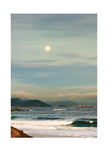 Luna sobre el mar con olas, montañas al fondo y un barco en el horizonte