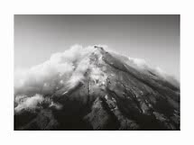 Zwart-witfoto van een bergtop omringd door wolken