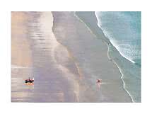 Aerial view of beach with waves, wet sand, an ATV and a person carrying a surfboard