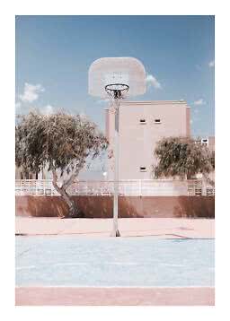 Outdoor basketball hoop on a pastel court with trees and a pale building under blue sky