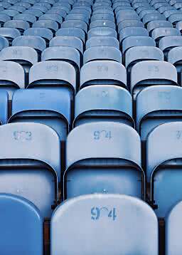 Reihen leerer blauer Stadionsitze mit Sitznummern