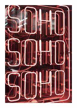 Enseigne lumineuse rose affichant SOHO SOHO SOHO sur fond sombre