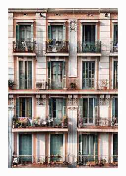 Apartment building facade with green shutters, wrought-iron balconies and plants