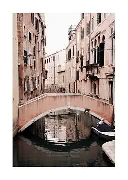 Small pink bridge over a narrow canal between old buildings, with a boat on the right