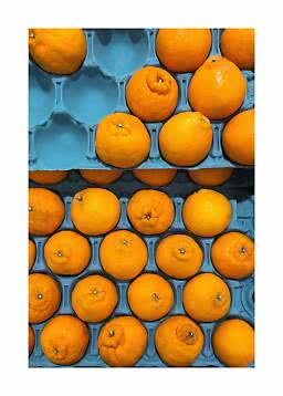 Orangen in gestapelten blauen Pappschalen