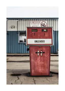 Bomba de gasolina vermelha vintage com letreiro Unleaded diante de um prédio azul e branco
