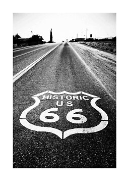 Sort-hvidt foto af en øde vej med Historic US 66-maleri på asfalten