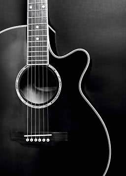 Close-up of a black acoustic cutaway guitar against a dark background