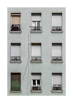 Apartment facade with nine windows, shutters, and small black balcony railings