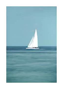 White sailboat on calm blue sea under a clear sky