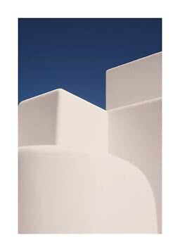Abstract architecture with cream-colored curved walls against a deep blue sky