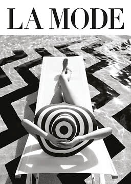 Black-and-white fashion image of person on lounger by pool with large striped hat